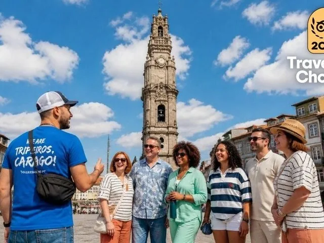 Ein Reiseleiter spricht zu einer Gruppe auf einem Platz mit einem hohen Turm.