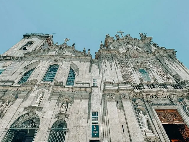Una vista de contrapicado de la ornamentada fachada de piedra de la Catedral de Oporto.